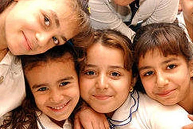 Four smiling children embracing for a photo at one of the Foundation's community programs