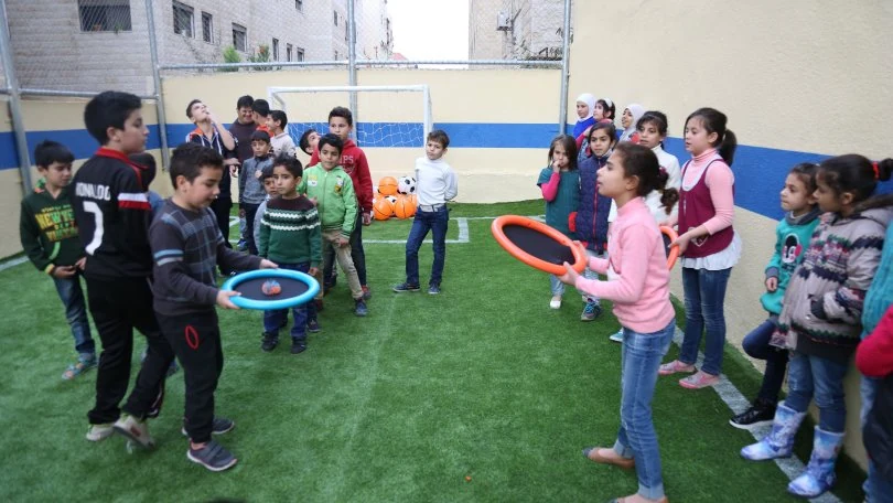 Children playing games together in a courtyard in Jordan